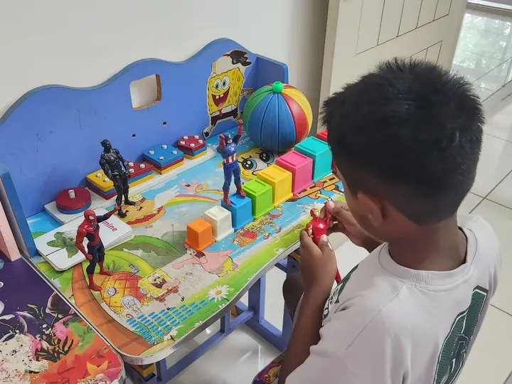 A child working with toys in the therapy room